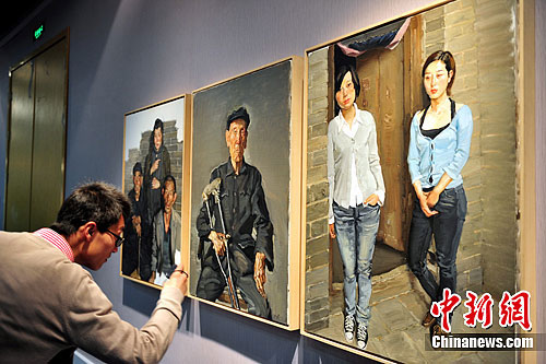 一名参观者正在为陈丹青的一幅油画拍照。刘占昆 摄